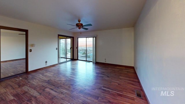 empty room with ceiling fan and dark hardwood / wood-style flooring