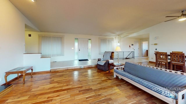 living room featuring lofted ceiling, ceiling fan, and light wood-type flooring