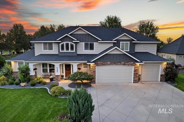 craftsman-style house with board and batten siding, covered porch, a shingled roof, and a front lawn