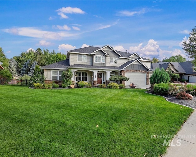 view of front of home with a front lawn, board and batten siding, an attached garage, and fence