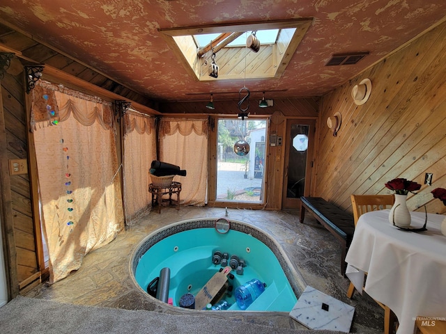 view of swimming pool featuring a skylight and an indoor hot tub