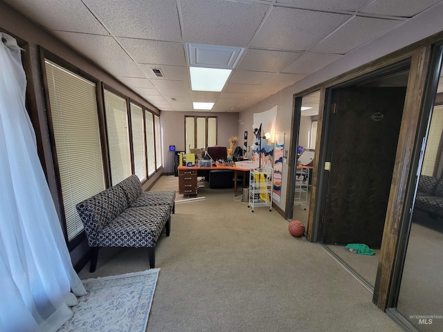 carpeted home office with a paneled ceiling