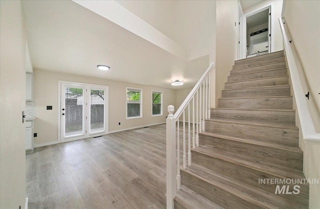 stairway with wood finished floors and baseboards