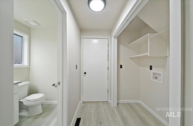 laundry area featuring light wood finished floors, washer hookup, and baseboards