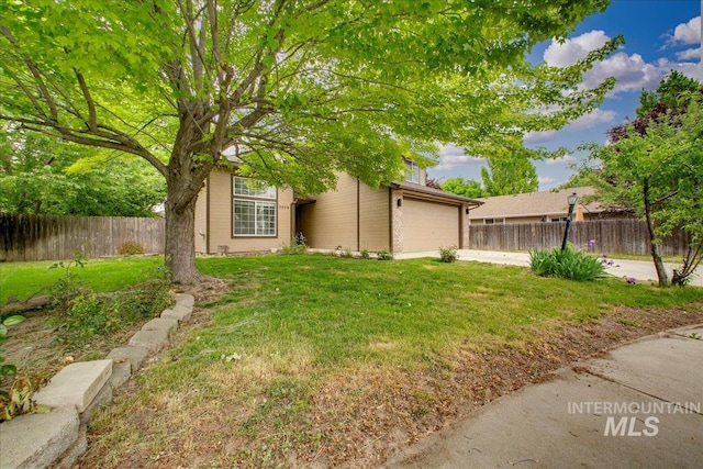 view of yard featuring concrete driveway and a garage