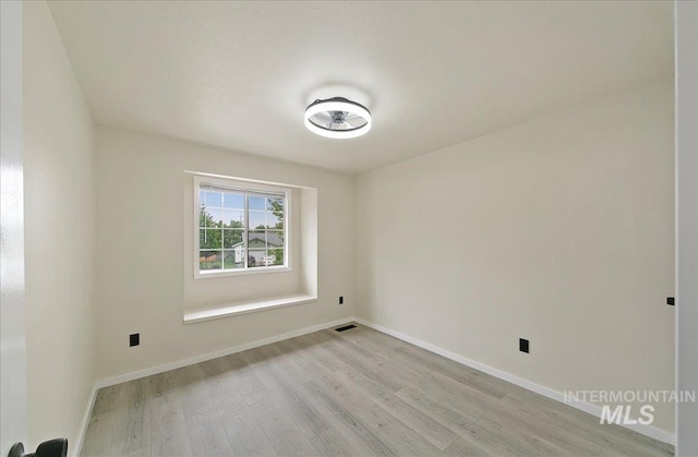 empty room with light wood-type flooring and baseboards