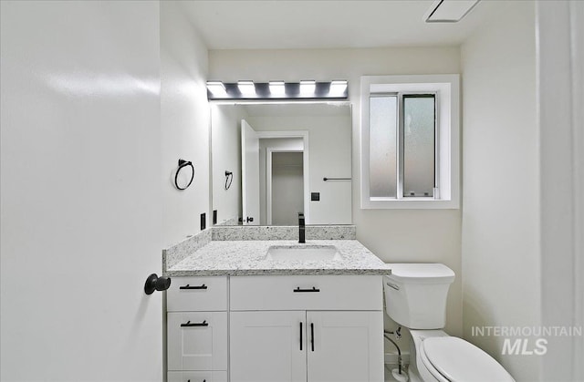 half bathroom featuring toilet and vanity