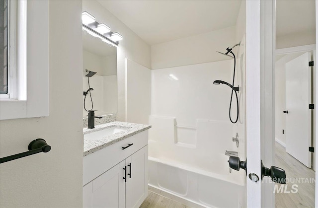 bathroom with  shower combination, wood finished floors, and vanity