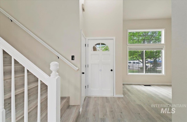 entryway with wood finished floors, stairs, and baseboards