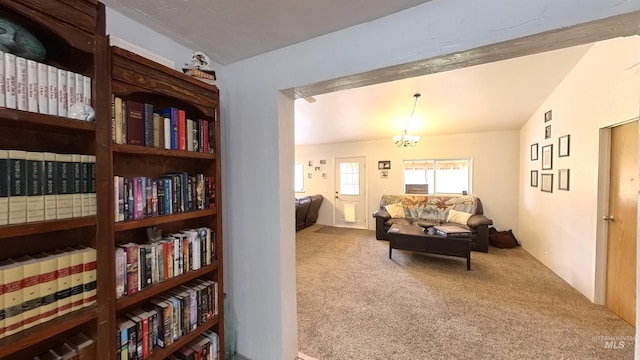 living area featuring an inviting chandelier, vaulted ceiling, and carpet flooring