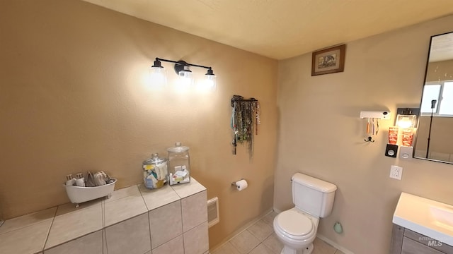 half bath with tile patterned flooring, toilet, visible vents, vanity, and baseboards