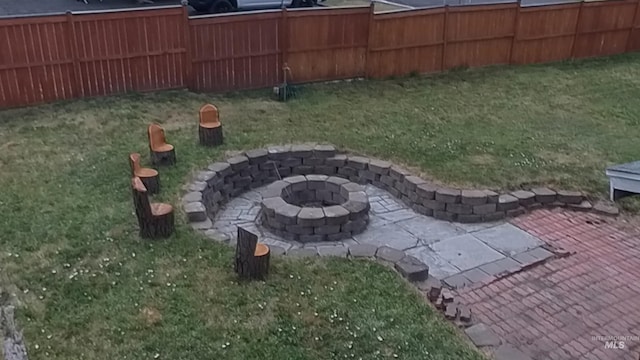 view of yard featuring an outdoor fire pit, fence, and a patio