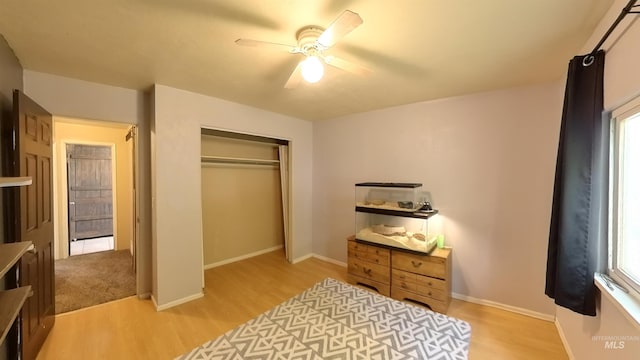 bedroom with a closet, light wood-style flooring, and baseboards