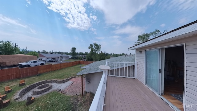 wooden deck featuring a yard, an outdoor fire pit, and fence