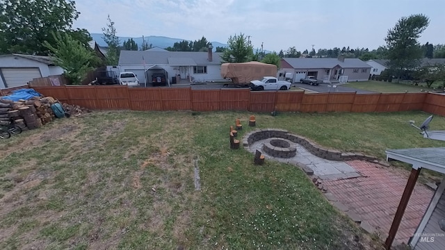 view of yard with an outdoor fire pit, a residential view, and fence