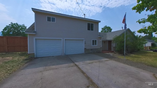 traditional-style house with concrete driveway, fence, and an attached garage