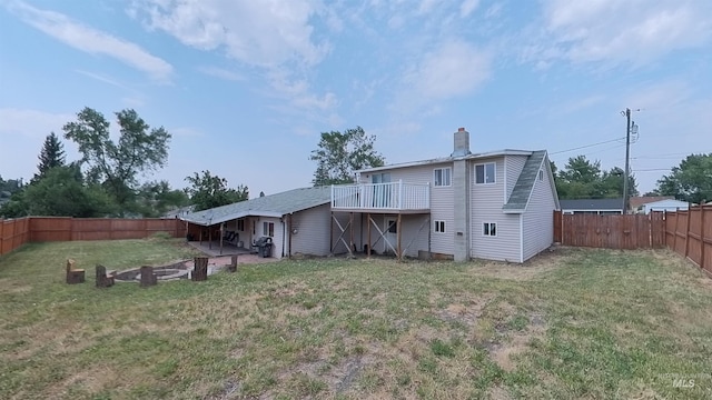 rear view of property with a fenced backyard, a chimney, and a lawn