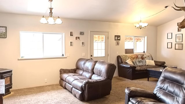 living area with a chandelier, carpet floors, and a wood stove