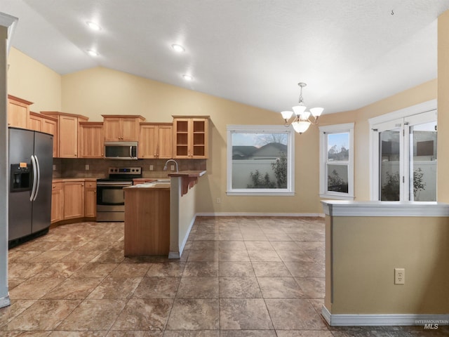 kitchen featuring stainless steel appliances, tasteful backsplash, a notable chandelier, decorative light fixtures, and vaulted ceiling