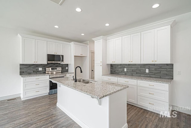 665 Emma Ct, Idaho Falls, ID 83404 - kitchen with stainless steel appliances, a sink, dark wood finished floors, tasteful backsplash, and white cabinets