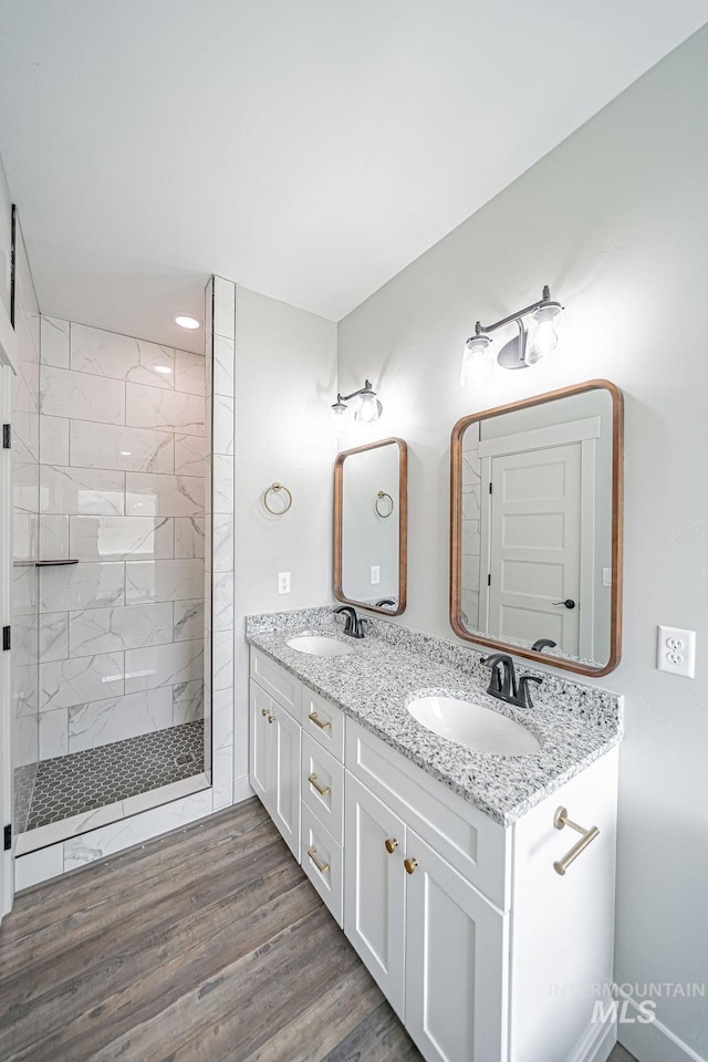 665 Emma Ct, Idaho Falls, ID 83404 - bathroom with double vanity, tiled shower, wood finished floors, and recessed lighting