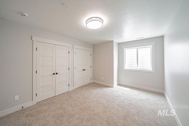665 Emma Ct, Idaho Falls, ID 83404 - unfurnished bedroom featuring two closets, light colored carpet, and baseboards