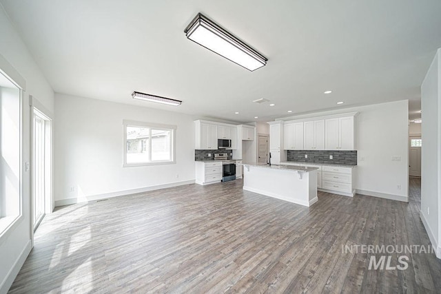 665 Emma Ct, Idaho Falls, ID 83404 - kitchen with stainless steel appliances, open floor plan, backsplash, white cabinets, and recessed lighting