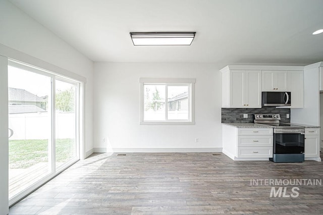 665 Emma Ct, Idaho Falls, ID 83404 - kitchen with appliances with stainless steel finishes, backsplash, white cabinets, and baseboards
