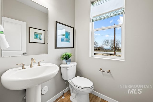 bathroom with a sink, wood finished floors, toilet, and baseboards