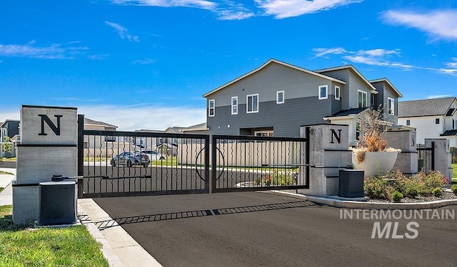 view of gate with fence and a residential view