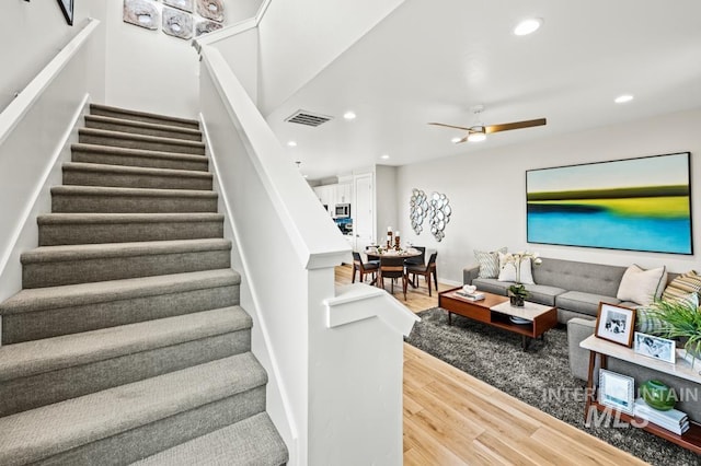 stairway featuring baseboards, visible vents, a ceiling fan, wood finished floors, and recessed lighting