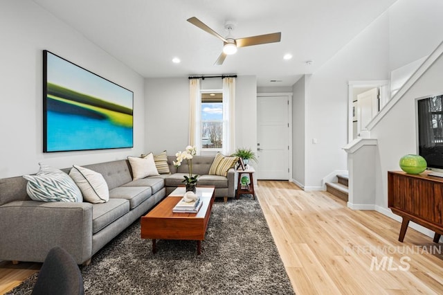 living area featuring baseboards, stairway, recessed lighting, and light wood-style floors