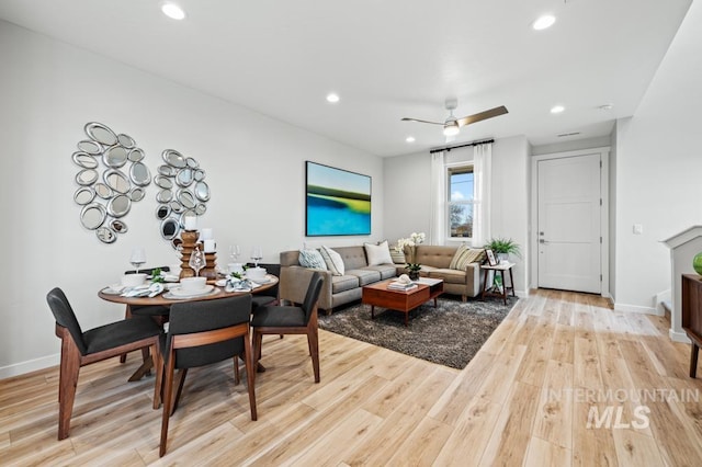 living room featuring baseboards, light wood finished floors, a ceiling fan, and recessed lighting