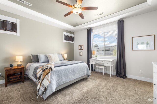 bedroom featuring a raised ceiling, baseboards, light colored carpet, and visible vents