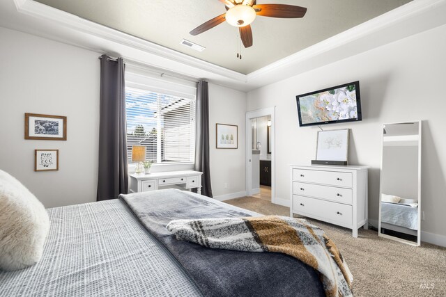 bedroom featuring light colored carpet, crown molding, visible vents, baseboards, and a tray ceiling