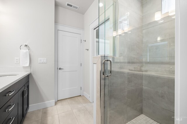 full bath featuring visible vents, vanity, tile patterned flooring, baseboards, and a shower stall