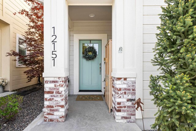 doorway to property featuring brick siding