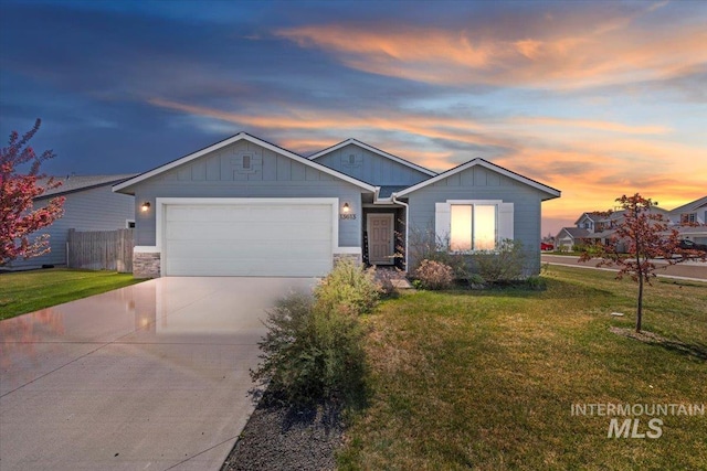 ranch-style house featuring an attached garage, board and batten siding, a yard, and driveway