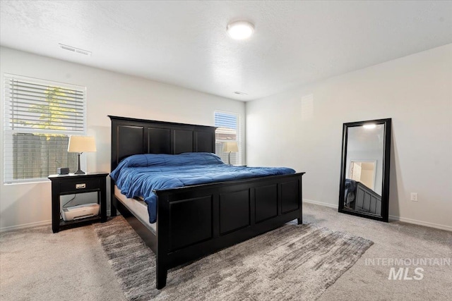 bedroom with baseboards, light colored carpet, and visible vents