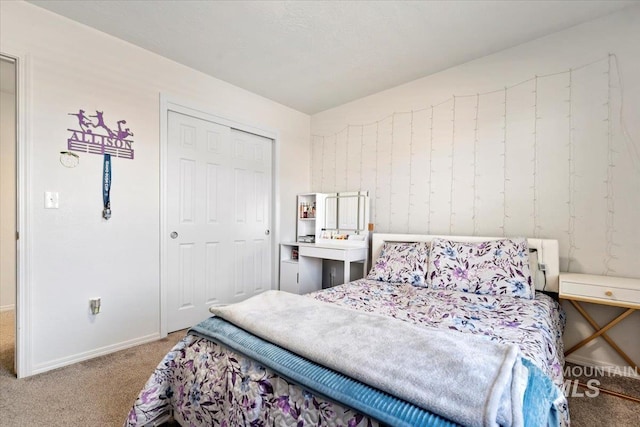 carpeted bedroom with baseboards and a closet