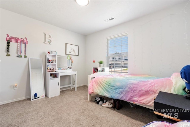 bedroom with visible vents, baseboards, and light carpet
