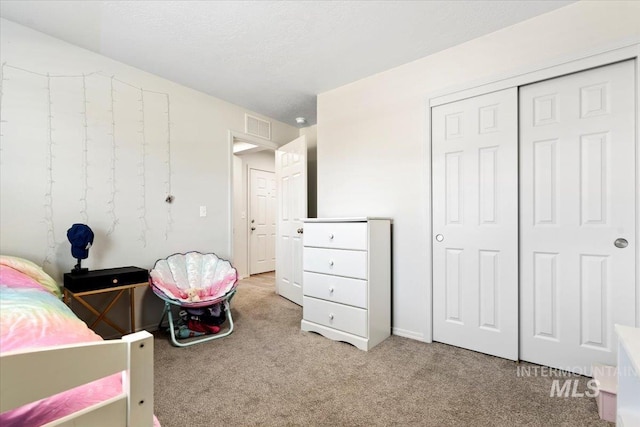 bedroom featuring visible vents, carpet, and a closet