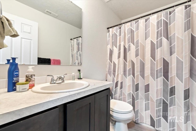 bathroom featuring toilet, visible vents, and vanity