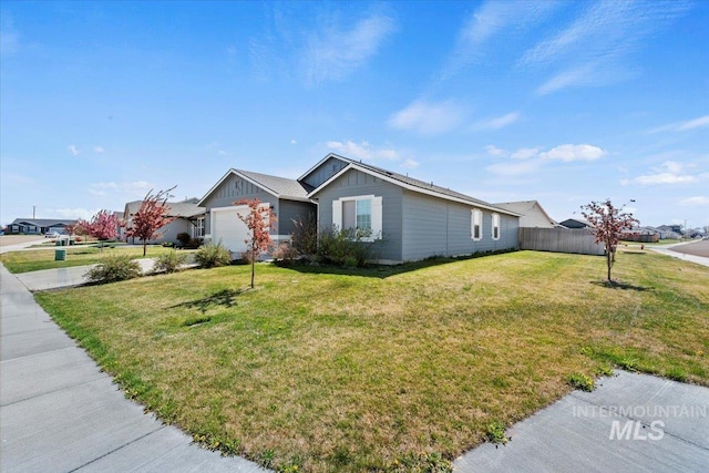 single story home with fence, board and batten siding, an attached garage, and a front lawn