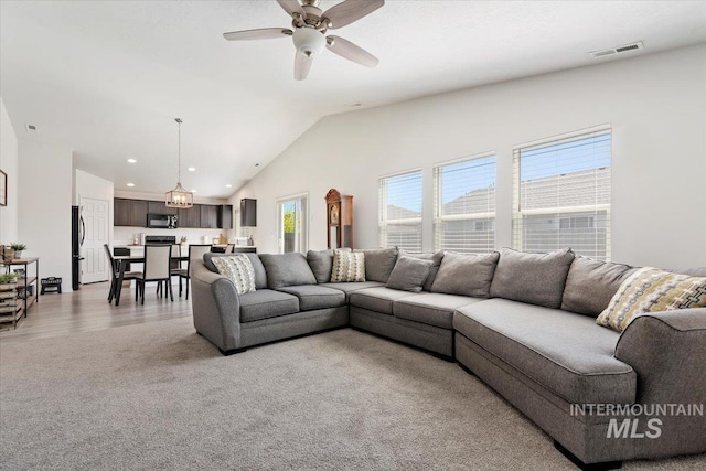 living room with visible vents, lofted ceiling, ceiling fan, recessed lighting, and light colored carpet