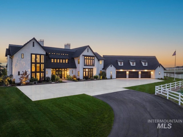 view of front of property featuring aphalt driveway, a garage, fence, and a front lawn