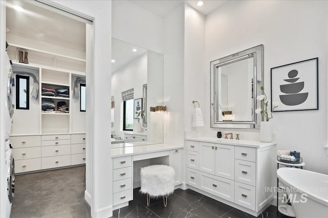 bathroom with a freestanding tub, recessed lighting, and vanity