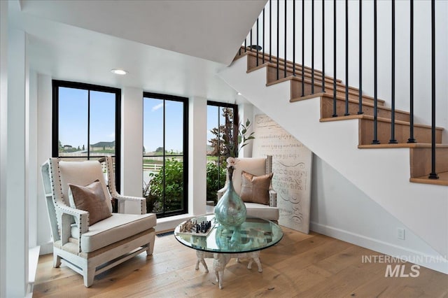 living area featuring stairway, baseboards, wood finished floors, and recessed lighting