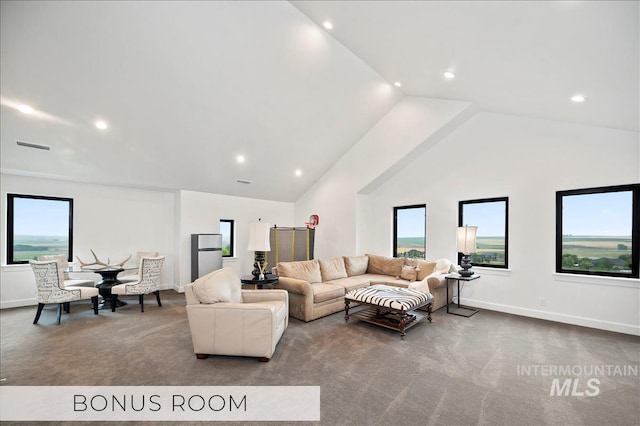 carpeted living area with baseboards, high vaulted ceiling, and a healthy amount of sunlight