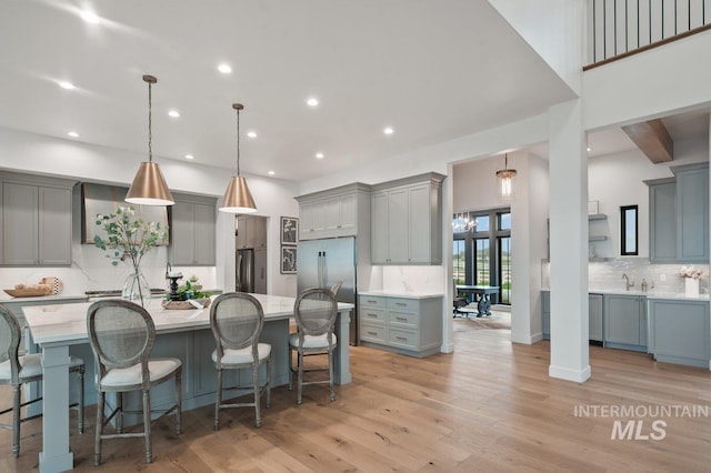 kitchen featuring light countertops, stainless steel fridge, gray cabinets, and light wood-style floors